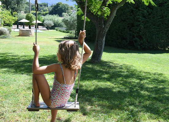 Petite fille à la balançoire dans le jardin de la location de vacances, la Maison de Becaras dans le Vaucluse